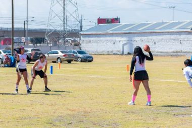 Group of teenagers playing flag football outdoors on a sunny day in Toluca, Mexico.